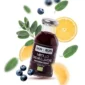 Organiczny napar z borówki, szałwii i cytryny w szklanej butelce. W tle borówki, cytryny i szałwia